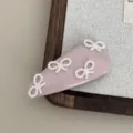 Close-up detail shot of the pink leather hair clip adorned with elegant white pearl bow accents. - Pink