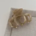 Vue rapprochée détaillée de l'élégante pince à cheveux en acétate pour le style quotidien. - Beige Jelly