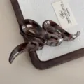 Detail view of the brown tortoise shell snake shaped hair claw clip for elegant styling. - Wave Claw Clip / 13cm / Gray Leopard
