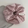 Close-up detail of a pink plaid fabric hair scrunchie showing soft texture and handmade label. - Korean Scrunchie - Pink Plaid