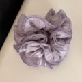 Detail shot of a light purple pleated chiffon hair scrunchie, showcasing textured fabric. - Ruffled Scrunchie / Purple