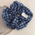 Detail shot of blue plaid fabric hair scrunchie with handmade label on cozy table surface. - Korean Scrunchie - Dark Blue Plaid