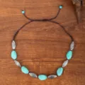 Close-up detail of vintage ethnic style braided necklace with turquoise stones and silver beads. - Turquoise Faux Stone with Antique Carved Metal Bead Style (C23-581)