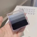 Detailed view of five seamless hair ties in gradient colors, neatly placed in a clear box. - Black-Grey Tones