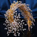 Close-up of exquisite handmade bridal pearl rhinestone gold leaf hair hoop accessory. - Gold