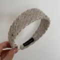 Detailed view of a cozy wide knitted wool hair hoop featuring a hand made label design. - Headband / Camel