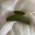 Close-up detail shot of a green hair claw clip, elegant jelly finish for daily styling. - Green