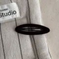Detailed close-up of a dark brown velvet BB hair clip on textured striped fabric, elegant and simple style. - Oval Clip / Dark Coffee