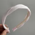 Detail view of a light pink twisted satin hair hoop, showcasing fine pleated texture and finish. - Simple Twist Headband / Light Pink