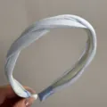 Detailed view of the elegant light blue satin twisted headband, featuring a chic textured design. - Simple Twist Headband / Blue