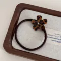 Leopard print acetate flower hair tie detail with sparkling center rhinestone on fabric tray. - Dark Small Flower Hair Tie / Leopard Print