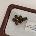 Detail shot of a leopard print acetate flower hair clip with a sparkly rhinestone accent. - Dark Small Flower Hair Claw Clip / Leopard Print