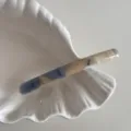 Vue détaillée d'une pince à cheveux fine en acétate avec un motif marbré bleu et beige. - Bleu Abricot