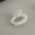 Detailed view of small transparent acetate hair claw clip, compact oval design with teeth grip. - Mermaid White
