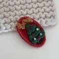 Closeup of cute handmade crochet Christmas tree hair clip, red and green knit winter hair accessory - Christmas Series - Red Base Tree