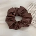 Detailed view of a soft brown leather scrunchie, elegant and chic hair tie for daily hairstyles. - Scrunchie / Light Coffee