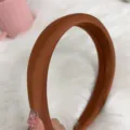 Cerchietto largo in satin marrone caramello, texture liscia per uno styling elegante. - Marrone