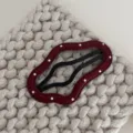 Gedetailleerde opname van bordeauxlederen golvende haarspeld met witte stippen op gebreid. - Wolk / Rood Met Witte Polkadots