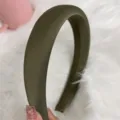 Primo piano dettagliato di un cerchietto imbottito in raso verde oliva minimalista. - Verde Scuro