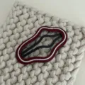 Gedetailleerde close-up van de unieke golvende lederen haarspeld met stijlvolle textuur. - Wolk / Rood met wit web