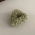 Detailed shot of the fluffy green plush hair accessory showing soft texture and cozy design. - Light Green