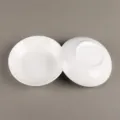 Vista detallada de un pequeño plato de cerámica blanca con diseño interior y base. - 4 Pulgadas