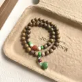 Vue détaillée d'un bracelet de perles en bois vintage à double tour avec pendentif lotus. - Style Capsule de Graine de Lotus