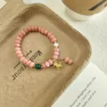 Detail view of sweet pink quartz abacus bead bracelet with cute gold charm and green accent bead. - Horse Pendant Style