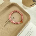 Pink quartz abacus bead bracelet detail, sweet gemstone jewelry piece with gold accents. - Red Agate Style