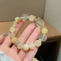 Close-up detail of the natural yellow quartz crystal bracelet featuring gold spacer beads. - Irregular Geometric Citrine Style