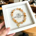 Détail du bracelet en agate orange et cristal délicat, design de niche doux avec pendentif perle. - Style Boucle de Sécurité en Résine