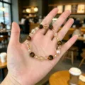 Vue détaillée du bracelet de perles sucré avec agate, cristal, perle et entretoises dorées. - 7 Style Œil de Tigre