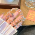 Gros plan du bracelet de perles œil de chat orange double rang avec charmant pendentif baleine. - Oeil de chat orange + Dauphin