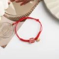 Red braided string bracelet with golden bell and charm for new year gift and trendy daily wear - Lucky Carp Possessed