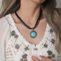 Close-up detail van vintage turquoise hanger ketting in boheemse stijl met zwarte koorden. - Textuur Ronde Turkoois Zwart Koord Stijl (C23-454 B4-F2)