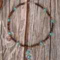 Handmade wooden bead necklace detail with turquoise stones and vintage silver pendant. - Metal Carved Pendant Style (C23-484)