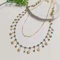 Collier ras de cou coquillage multicouche doré avec cristaux bleus, détail style vintage. - Style Double Couche C24-005