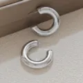 Gros plan détaillé de boucles d'oreilles créoles épaisses argentées à finition métallique. - Style Grand Forme C Épais (A24-106R Grand)