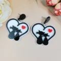 Close-up detail of cute black and white cat heart acrylic earrings for sweet dating styles. - Kissing Black and White Cats Heart Style