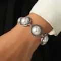 Vintage style silver-toned bracelet featuring ornate round faux pearl links for women. - White Faux Pearl Style / Silver