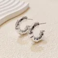 Close-up detail of silver bamboo textured hoop earrings, showing unique geometric metallic shine. - 2.9cm / Medium Bamboo A24-103R / Silver