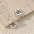 Gros plan boucles d'oreilles créoles épaisses argentées, design en C épuré et poli brillant. - Style Moyen Forme C Épais (A24-106R Moyen)