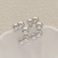 Vue détaillée en gros plan de boucles d'oreilles créoles sphériques en métal argenté poli. - Style C Enfilé de Perles (A24-104R)