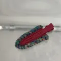 Detail view of a stylish color-contrast wool woven duckbill hair clip, perfect for daily styling. - Seamless Clip / Red