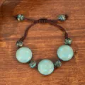 Close-up shot of ethnic vintage style beaded bracelet featuring blue carved charms. - Carved Disc Style (B23-294)