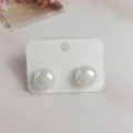 Iridescent mermaid pearl ear studs detail view, elegant white pearl design on display card. - L / White