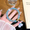 Primo piano del braccialetto di perline di vetro blu con un delizioso ciondolo di loto bianco e trama. - Stile Mughetto in Vetro Blu