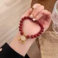 Gros plan détaillé d'un bracelet de perles rouges avec pendentif cadenas doré, élégant. - Style Pendentif Cadenas Résine