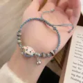 Detailed close-up view of the woven ceramic lucky cat bracelet featuring beads and bell charm. - Blue Series