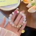 Detailed view of the Chinese style lotus and gemstone bracelet with delicate beads. - 2 White Agate